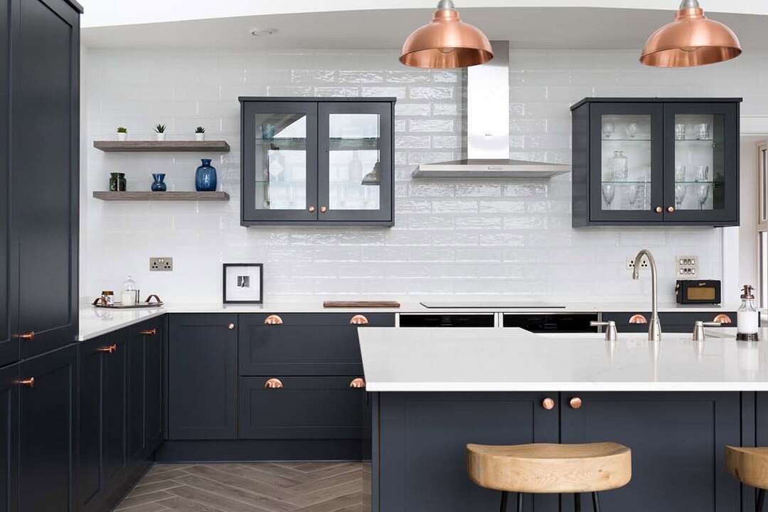 Luxury modern Callerton kitchen featuring black cupboards and white worktops, showcasing a kitchen island alongside barstools